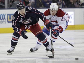 Columbus Blue Jackets' Cam Atkinson, left, carries the puck up ice against Montreal Canadiens' Jacob De La Rose during the second period of an NHL hockey game Thursday, Feb. 26, 2015, in Columbus, Ohio.