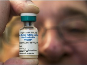 In this Thursday, Jan. 29, 2015 photo, a pediatrician holds a dose of the measles-mumps-rubella (MMR) vaccine at his practice in Northridge, Calif.