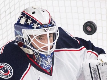 Columbus Blue Jackets goaltender Curtis McElhinney keeps his eyes on the puck as he makes a save on the Montreal Canadiens during first period NHL hockey action in Montreal, Saturday, February 21, 2015.
