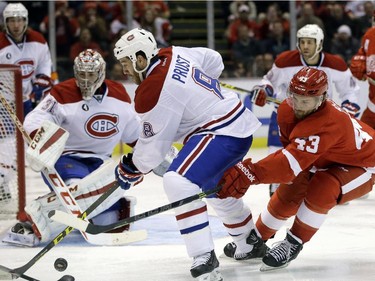 Montreal Canadiens right wing Brandon Prust (8) controls the puck in front of Detroit Red Wings centre Darren Helm (43) during the second period of an NHL hockey game Monday, Feb. 16, 2015, in Detroit.