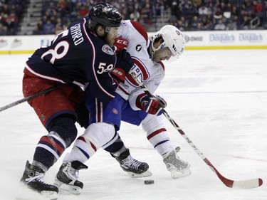 Montreal Canadiens' David Desharnais, right, keeps the puck away from Columbus Blue Jackets' David Savard during the third period of an NHL hockey game Thursday, Feb. 26, 2015, in Columbus, Ohio. The Canadiens beat the Blue Jackets 5-2.