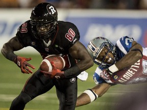 Ottawa Redblacks wide receiver Dobson Collins is tackled by Montreal Alouettes linebacker Kyries Hebert during second quarter CFL football action Friday, August 29, 2014 in Montreal.