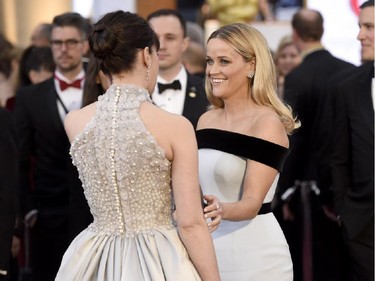 Felicity Jones, left, and Reese Witherspoon speak on the red carpet at the Oscars on Sunday, Feb. 22, 2015, at the Dolby Theatre in Los Angeles.