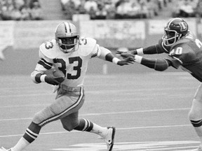In this Dec. 18, 1977 file photo, the Dallas Cowboys' Tony Dorsett tries to get past Denver Broncos safety Billy Thompson during NFL game in Irving, Tex.