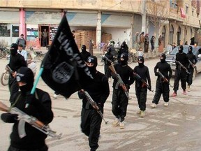 Image posted on a militant website Jan. 14, 2014, shows fighters from al-Qaida linked Islamic State of Iraq and the Levant (ISIL) marching through Raqqa, Syria.