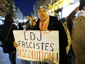 A protester holds a placard reading "LDJ - fascists - dissolution" during a demonstration with about 120 members of the "Indigenous of the Republic's Party" (PIR), on November 8, 2012 in front of France's Justice Ministry in Paris.