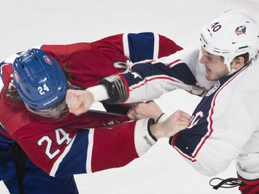 Montreal Canadiens' Jarred Tinordi, left, fights with Columbus Blue Jackets' Jared Boll during first period NHL hockey action in Montreal, Saturday, February 21, 2015.