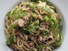 Canned tuna is combined with hot pasta and arugula in this easy supper dish.