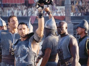 Maximus (Russell Crowe, centre) and his fellow gladiators, including Juba (Djimon Hounsou, right) and Hagen (Ralf Moeller, left), salute the cheering spectators at the Colosseum in Gladiator.