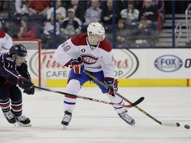 Montreal Canadiens' Michael Bournival, right, and Columbus Blue Jackets' Matt Calvert chase a loose puck during the first period of an NHL hockey game Thursday, Feb. 26, 2015, in Columbus, Ohio.