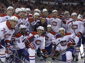 Canadiens assistant equipment manager Patrick Langlois (centre, in blue shirt) is surrounded by members of the team at Detroit's Joe Louis Arena on Feb. 16, 2015. Langlois is holding a souvenir game puck presented to him in honour of his 2,000th professional hockey game worked.