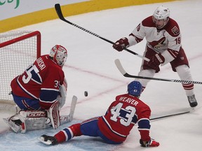 The Arizona Coyotes' Shane Doan takes a backhand shot on Canadiens goalie Dustin Tokarski, while Mike Weaver tries to cover during second period action at the Bell Centre on Feb. 1, 2015.