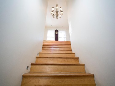 A grandfather clock sits in the middle of the house, at the top of the staircase.