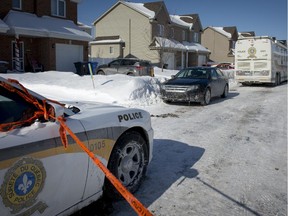 Sûreté du Québec vehicles outside the home where a 7-year-old girl was found dead and her mother in critical condition.