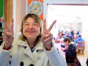 Helen Jolly flashes a peace sign on Saturday at Chez Doris, which has resumed its weekend services.
