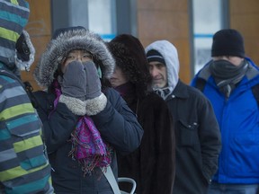 Commuters brave the cold as they wait for the 211 Bord-du-Lac bus, on Monday Feb. 16, 2015 at the Lionel-Groux metro station.