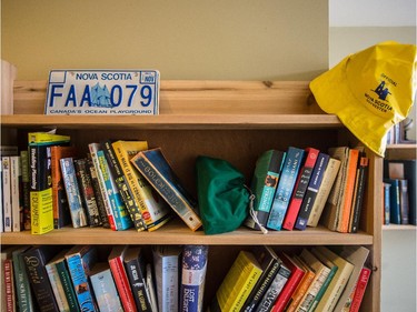 A bookcase with a Nova Scotia licence plate and Sou'wester rain hat.