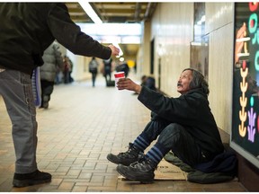 Simeonie Tuckatuck, 58, who has been living homeless in Montreal for three years, panhandles indoors at the Promenades Cathédrale near the McGill metro station in Montreal on Feb. 18, 2015.