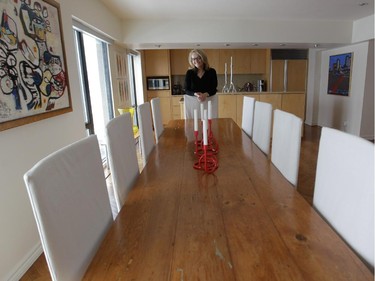 Anne Darche at the end of an antique pine refectory table in her dining room.