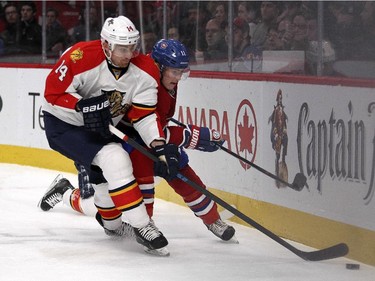Montreal Canadiens Brendan Gallagher is bumped off the puck by Florida Panthers  Tomas Fleischmann, left, during first period of National Hockey League game in Montreal Thursday February 19, 2015.