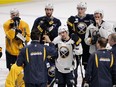 Brian Gionta (centre in white jersey), captain of the Buffalo Sabres listens to head coach Ted Nolan during practice at the Bell Centre on Feb. 2, 2015.