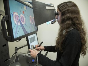 High-school student Rebecca Falutz uses a simulator to test her skills as a neurosurgeon at the Montreal Neurological Institute simulations centre in Montreal, Saturday, Feb. 21, 2015.