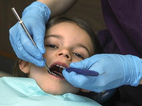 Five- year-old Myriam Stewart has her teeth cleaned by dental hygienist Kayla Giacomodonato in Montreal, Thursday Feb. 26, 2015.