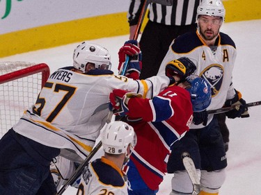 Buffalo Sabres defenceman Josh Gorges, right, looks on as Buffalo Sabres defenceman Tyler Myers, left, punches Montreal Canadiens right wing Brendan Gallagher in the face during NHL action at the Bell Centre in Montreal on Tuesday February 3, 2015.