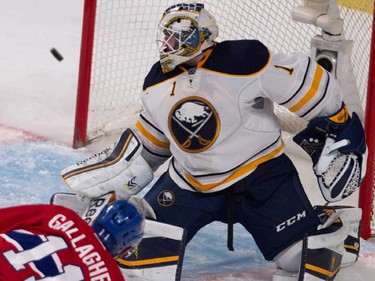 Buffalo Sabres goalie Jhonas Enroth, top, deflects a shot by Montreal Canadiens right wing Brendan Gallagher during NHL action at the Bell Centre in Montreal on Tuesday February 3, 2015.