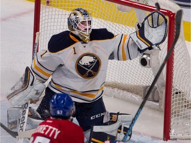 Buffalo Sabres goalie Jhonas Enroth, top, makes a glove save against Montreal Canadiens left wing Max Pacioretty  during NHL action at the Bell Centre in Montreal on Tuesday February 3, 2015.