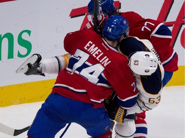 Buffalo Sabres left wing Tyler Ennis, centre, gets sandwiched between Montreal Canadiens defenceman Alexei Emelin and Montreal Canadiens defenceman Tom Gilbert, rear, during NHL action at the Bell Centre in Montreal on Tuesday February 3, 2015.