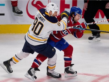 Montreal Canadiens centre David Desharnais grimaces as he is hit by Buffalo Sabres right wing Chris Stewart during NHL action at the Bell Centre in Montreal on Tuesday February 3, 2015.