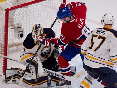 Montreal Canadiens centre Lars Eller (centre) tries to tip the puck in the net as Buffalo Sabres goalie Jhonas Enroth makes a pad save during NHL action at the Bell Centre in Montreal on Tuesday February 3, 2015. Buffalo Sabres defenceman Tyler Myers, right, looks on.