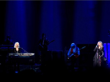 Singers Christine McVie (left) and Stevie Nicks of the band Fleetwood Mac perform beside bassist John McVie during the band's show at the Bell Centre in Montreal on Thursday, February 5, 2015.