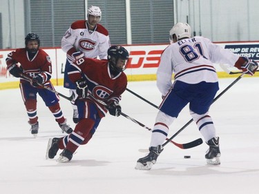 Lars Eller of the Montreal Canadiens defends against Noah Gaudette of the AAA pee wee team called Conquérants des Basses-Laurentides during a scrimmage at Bell Sports Complex in Brossard in Montreal, on Friday, February 6, 2015. Behind, Max Pacioretty stays close to Alexis Bolduc. The team will be representing the Canadiens at the upcoming Quebec City pee wee tournament.