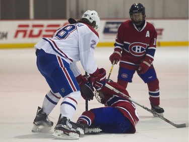 The Canadiens' Nathan Beaulieu playfully pins Félix Trudeau of the Basse Laurentides Conquérents pee-wee team to the ice, much to the delight of teammate William Lavigne, during a scrimmage at the Bell Sports Complex in Brossard on Feb. 6, 2015.
