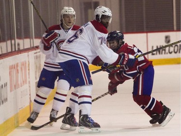 P.K. Subban of the Montreal Canadiens holds up William Lavigne of the AAA pee wee team called Conquérants des Basses-Laurentides during a scrimmage at Bell Sports Complex in Brossard in Montreal, on Friday, February 6, 2015. The team will be representing the Canadiens at the upcoming Quebec City pee wee tournament. On the left is Christian Thomas.