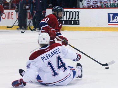 Tomas Plekanec  of the Montreal Canadiens falls down as William  Lavigne of the AAA pee wee team called Conquérants des Basses-Laurentides flies by him during a scrimmage at Bell Sports Complex in Brossard in Montreal, on Friday, February 6, 2015. The young team will be representing the Canadiens at the upcoming Quebec City pee wee tournament.