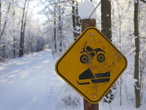 A sign showing a crossing for snowmobiles and ATVs.