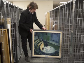 Jean-Paul Bégin, collection technician at the MUHC Art and Heritage Centre, with a painting by Norman Bethune, titled "Night Operating Theatre," which was painted from the audience seats in the old Royal Victoria Hospital surgical theatre, signed and dated 1935.