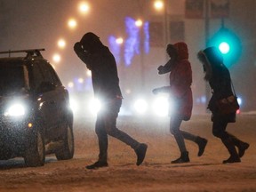 People scurry across René Lévesque Blvd. in Montreal, Jan. 3, 2015.