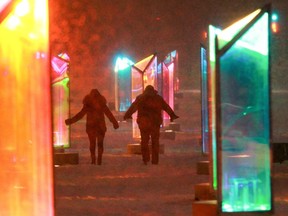 People walk through the Lumino Thérapie installation at the Quartier des Spectacles.
