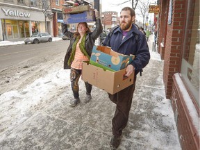 Jamie Klinger right, carries the collected fruits and vegetable with another resident left, of the co-op they live in, that they just picked up from a local store in Montreal, on Friday, January 30, 2015.