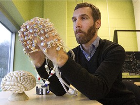 Dave Ellemberg , a professor of kinesiology and neuropsychologist , shows how an electrodes sensor net can record brain activity in his lab at l'Université de Montréal on Nov. 13, 2013.