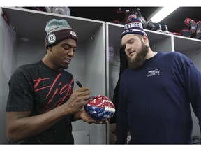 MONTREAL, QUE.: November 24, 2014 -- Montreal Alouettes reciever Duron Carter, left, autographs a souvenir football for team-mate Jeff Perrett as the team cleaned out their lockers at the Olympic Stadium in Montreal Monday November 24, 2014 one day after ending their season with a loss to Hamilton in the CFL Eastern Final.  Carter is expected to sign with an NFL team in the off-season. (John Mahoney / MONTREAL GAZETTE)