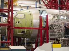 Workers working on the fuselage of a new Bombardier CSeries CS100 airplane at Bombardier's manufacturing plant on Marcel-Laurin boulevard in Montreal on Monday, October 15, 2012.