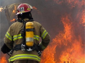 A firefighter walks to a fire.
