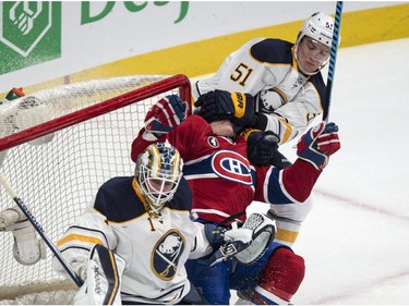 Montreal Canadiens' Brendan Gallagher gets a glove in the face by Buffalo Sabres' Nikita Zadorov as he is taken out next to goalie Jhonas Enroth during first period NHL hockey action Tuesday, February 3, 2015 in Montreal.