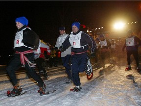 Participants race in a nighttime Tuques Bleues snowshoe event in support of the Friends of the Mountain / Les Amis de la Montagne on Mont Royal in Montreal Thursday Feb. 20, 2003.