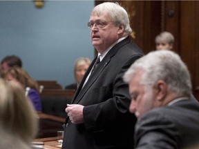 Quebec Health Minister Gaetan Barrette responds to Opposition questions as the government invokes closure to pass special legislation on health Friday, February 6, 2015 at the legislature in Quebec City. Quebec Premier Philippe Couillard, right, looks on.
